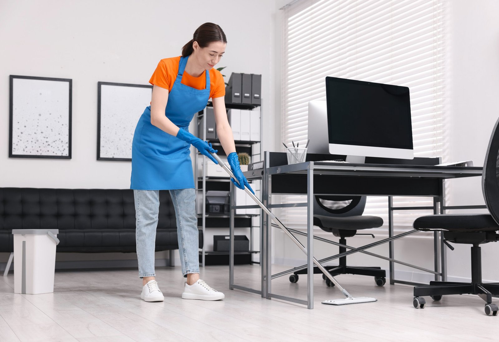 Cleaning service. Woman washing floor with mop in office